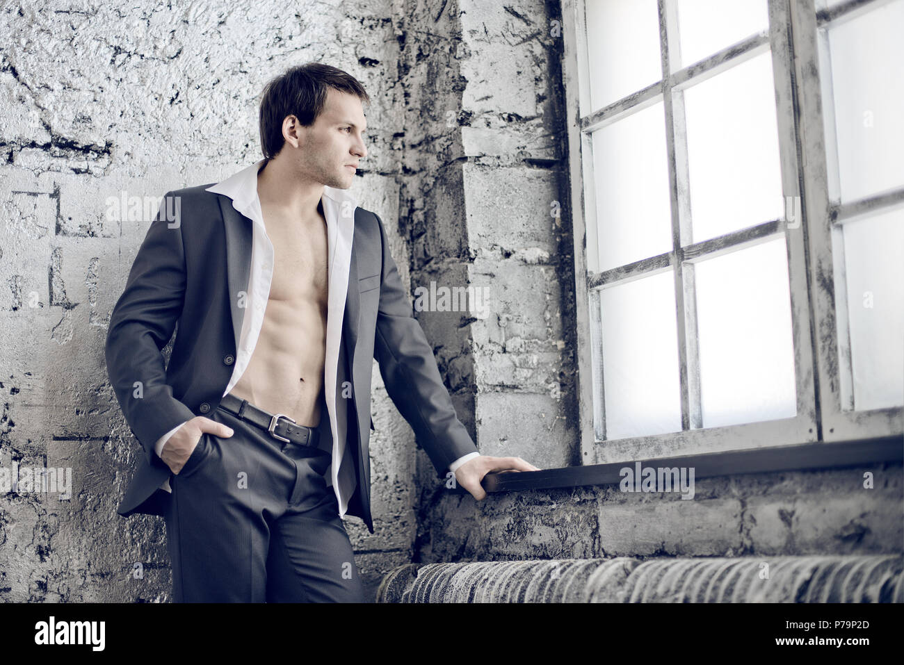 Il muscoloso bello sexy guy in abito nero indoor Foto Stock