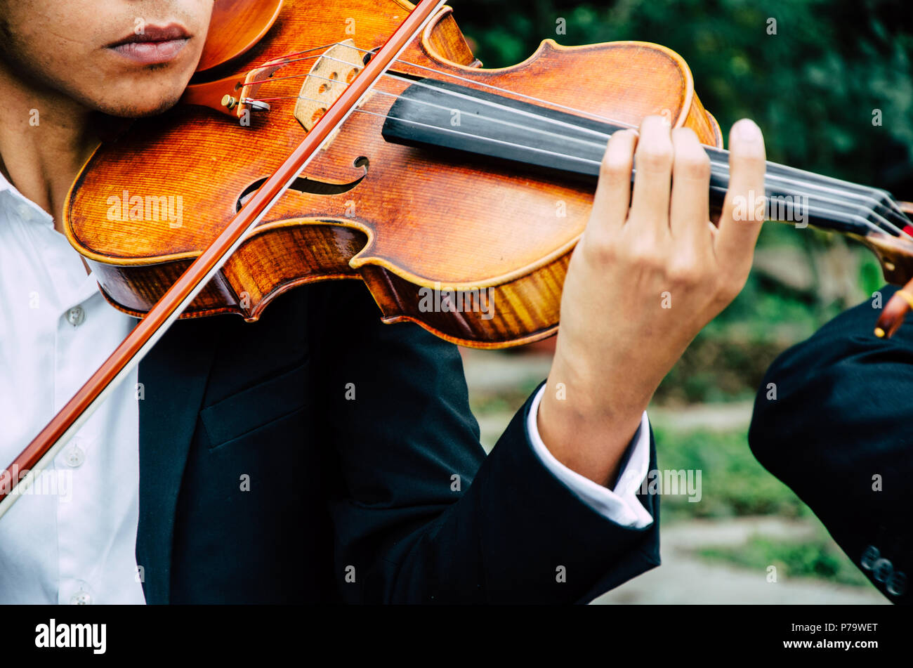 Arte e artista. Giovane uomo elegante violinista suona il violino sul nero. Musica classica. Little Boy strumento musicale. Foto Stock