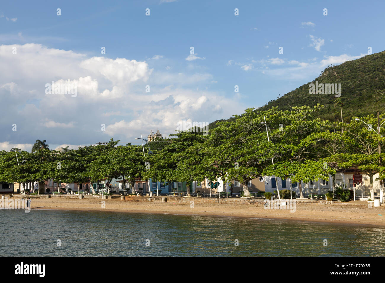 Florianopolis, stato di Santa Catarina, Brasile. Bellissima spiaggia paesaggio in un villaggio di pescatori con alberi, case colorate e cielo blu d'estate. Foto Stock