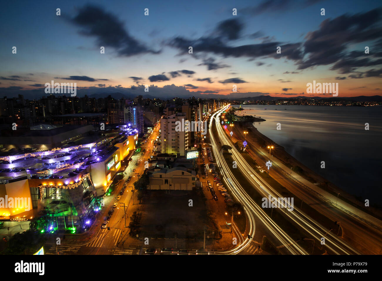 Florianopolis, Santa Catarina, Brasile. Una lunga esposizione fotografia di vista notturna del centro cittadino e la spiaggia al tramonto. Foto Stock