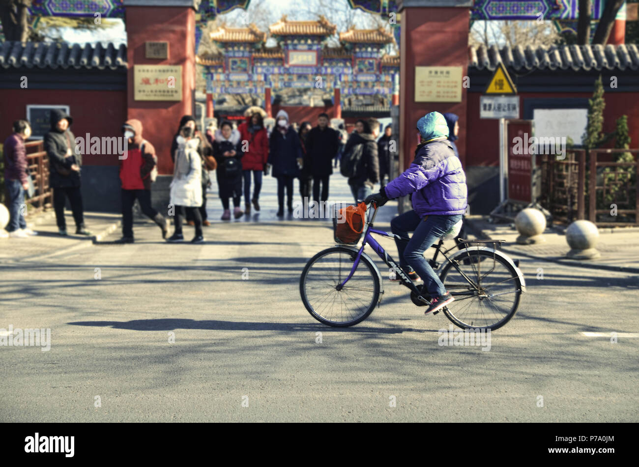 Ciclista passa nella parte anteriore del tempio Yonghe, Pechino Foto Stock