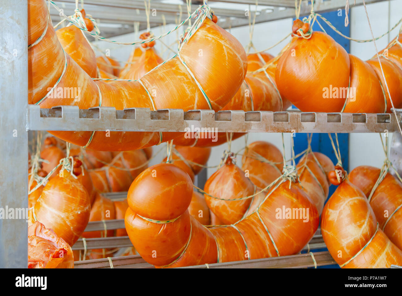 La salsiccia. Salsiccia della linea di produzione. Salsicce sul contatore per la smokehouse. Produzione industriale di salumi. Foto Stock