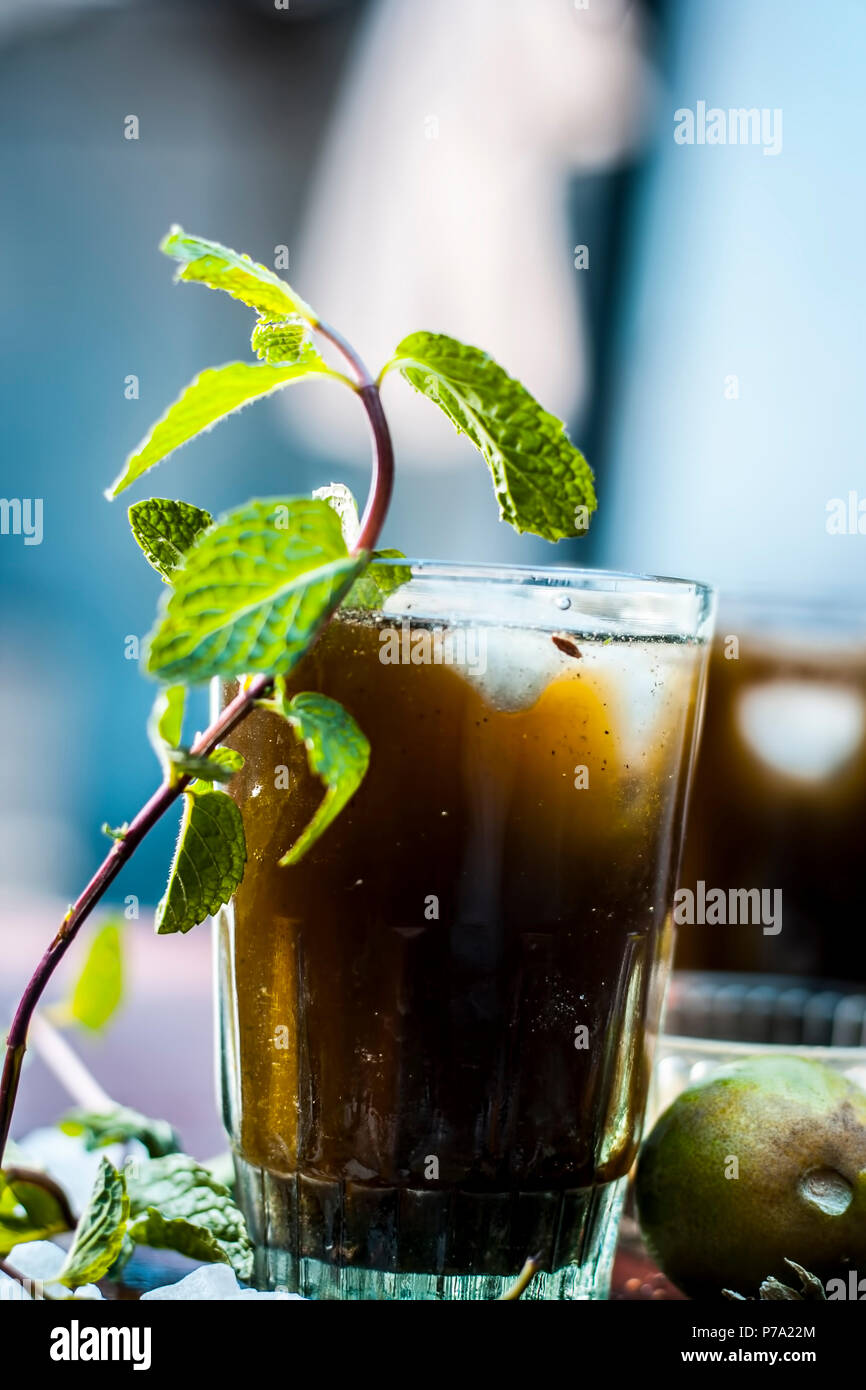 Close up di Asian popolare bevanda estiva cioè Phudina ka shrbat o drink alla menta con tutti i suoi ingredienti su di una superficie di legno che sono zucchero,con foglie di menta Foto Stock