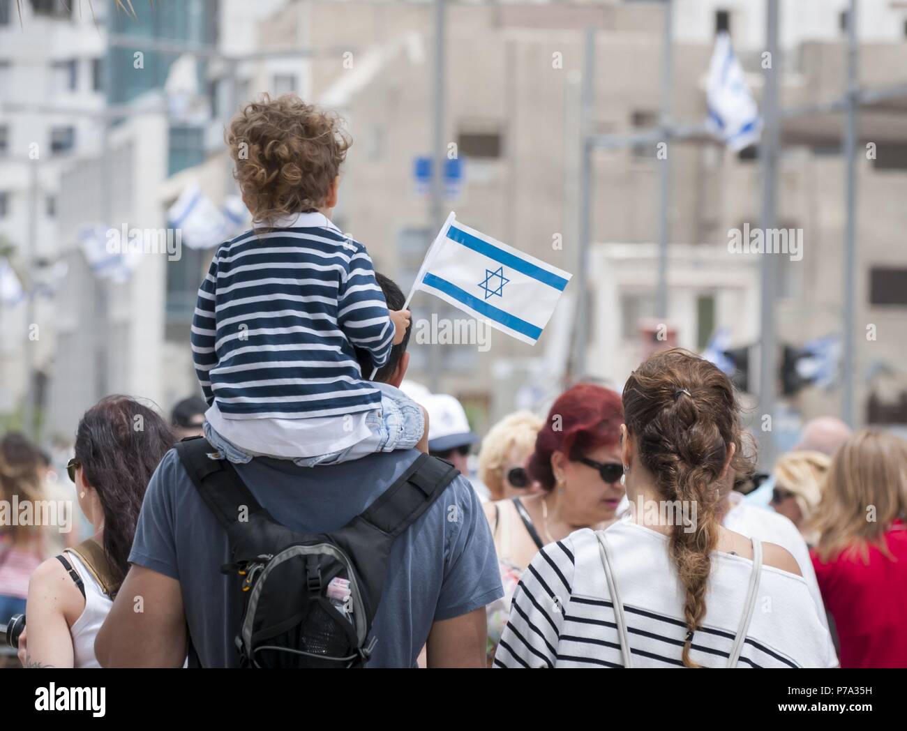 TEL AVIV, Israele. Maggio 2014. Padre e figlio con una bandiera in mano a piedi con la folla di Tel Aviv promenade. L'Israele il giorno di indipendenza. Foto Stock