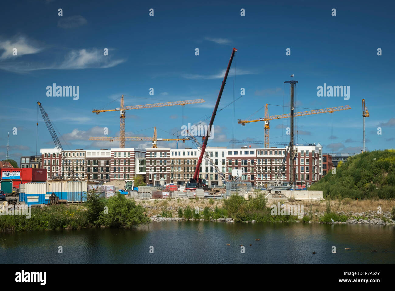 Un wir guerra di alta gru salire al di sopra di un nuovo sviluppo residenziale nel vecchio porto di Amsterdam. Foto Stock