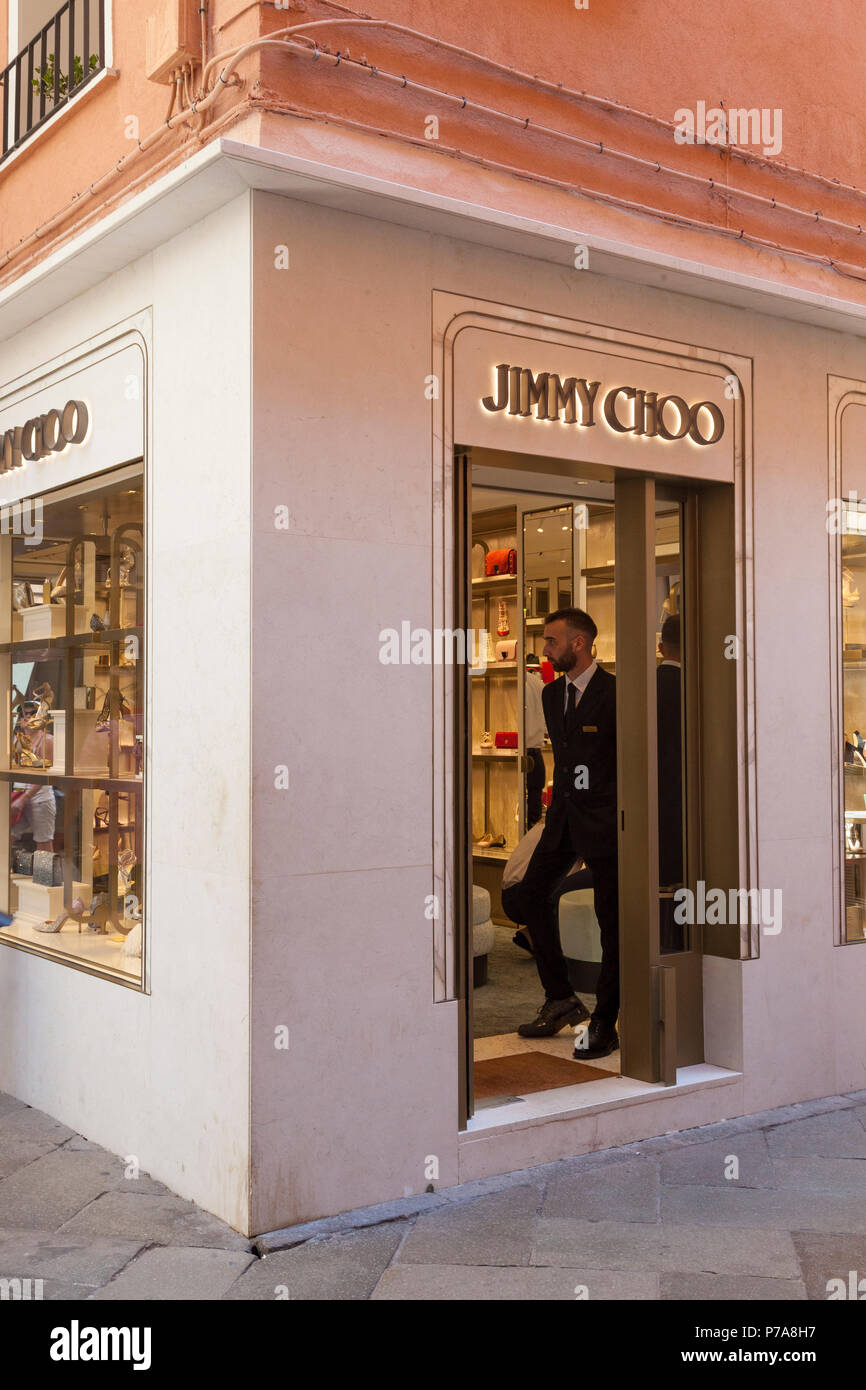 Il Jimmy Choo Store, Piazza San Marco, Venezia, Veneto, Italia vendita di scarpe da donna e accessori. Porta con portiere ed esterno con segno. Foto Stock