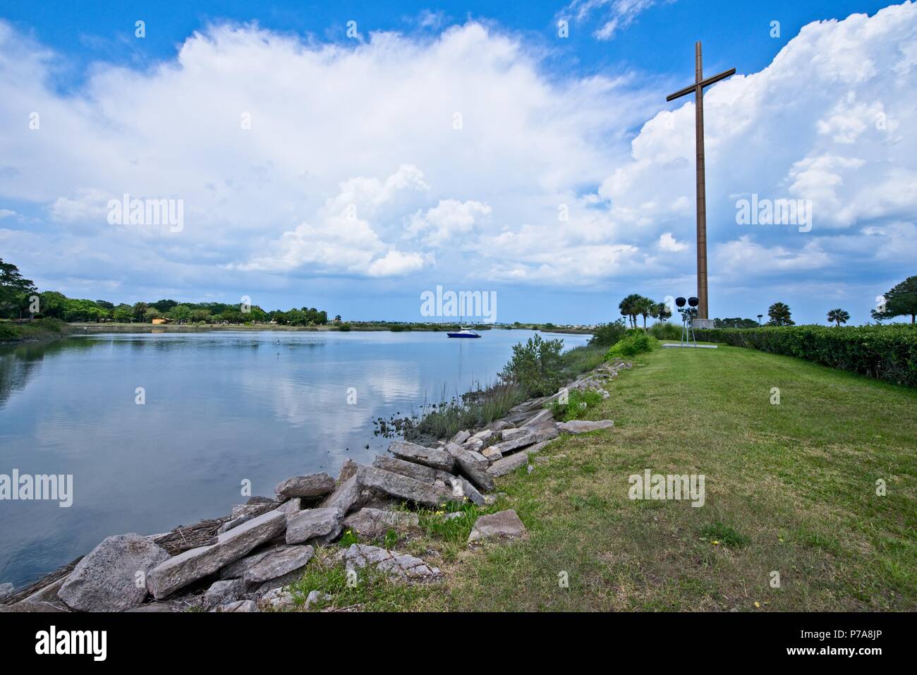 La croce, un simbolo del cristianesimo si trova lungo la tranquilla acqua Foto Stock