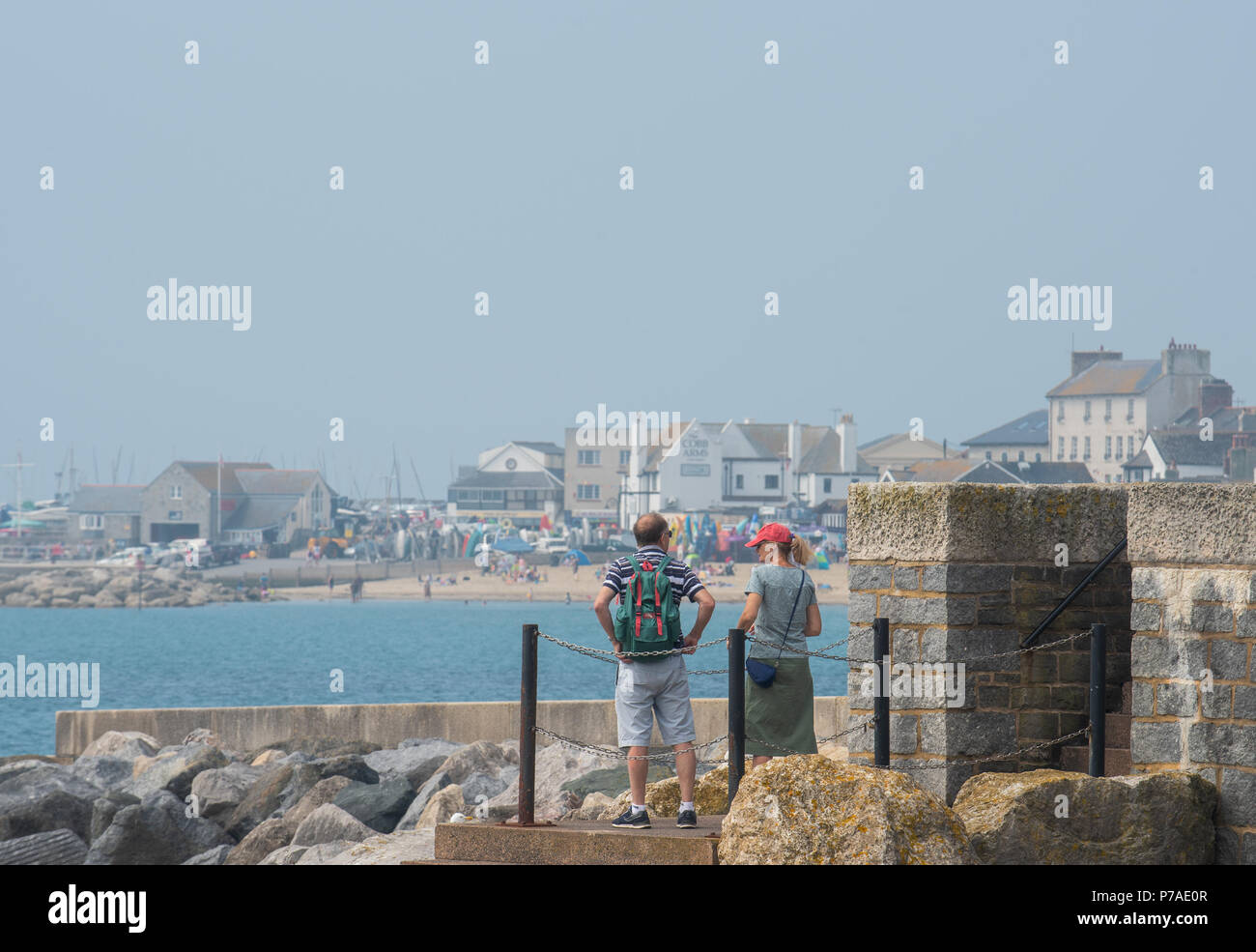 Lyme Regis, Dorset, Regno Unito. Il 5 luglio 2018. Regno Unito: Meteo caldo con sole nebuloso di Lyme Regis. I visitatori locali e testa per la spiaggia del resort costiero di Lyme Regis. Le prospettive sono buone con alta pressione brigning dominante condizioni di caldo e umidità per il weekend. Credito: Celia McMahon/Alamy Live News Foto Stock