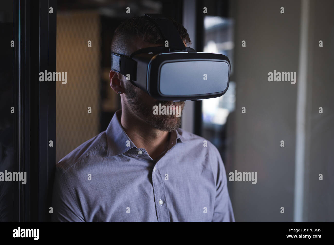Imprenditore utilizzando la realtà virtuale auricolare Foto Stock