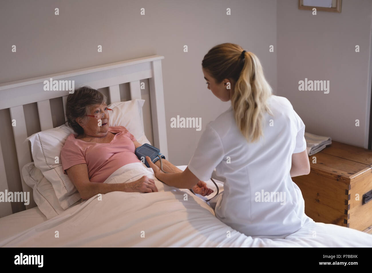 Fisioterapista controllando la pressione del sangue di donna senior Foto Stock