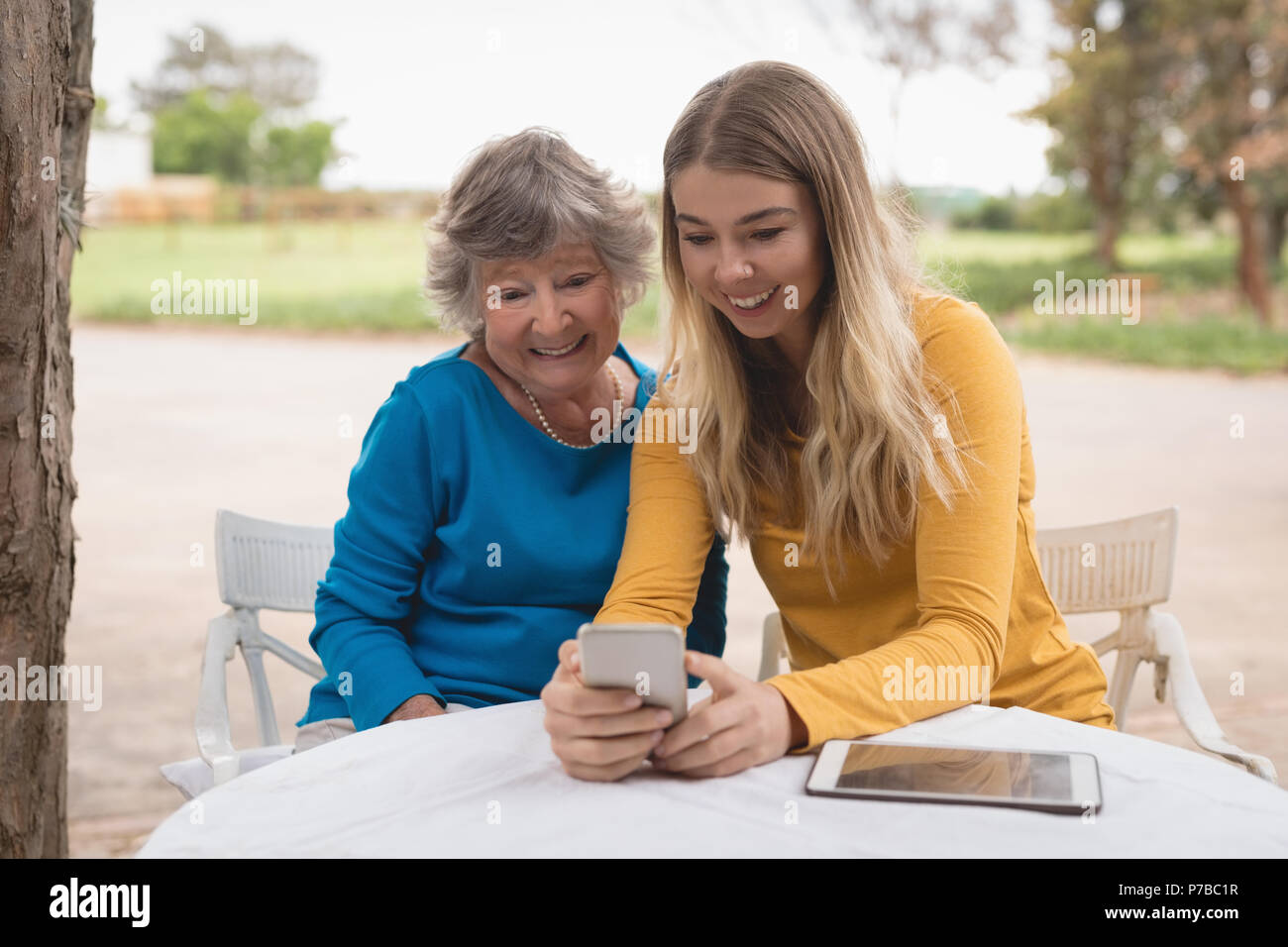 La nipote e nonna utilizzando uno smartphone Foto Stock