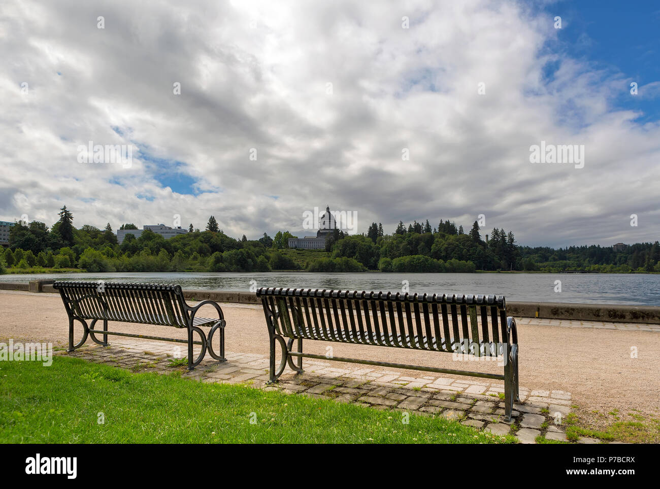 Una panchina nel parco lungo la panoramica Lago Capitol in Olympia nello Stato di Washington in un giorno nuvoloso Foto Stock