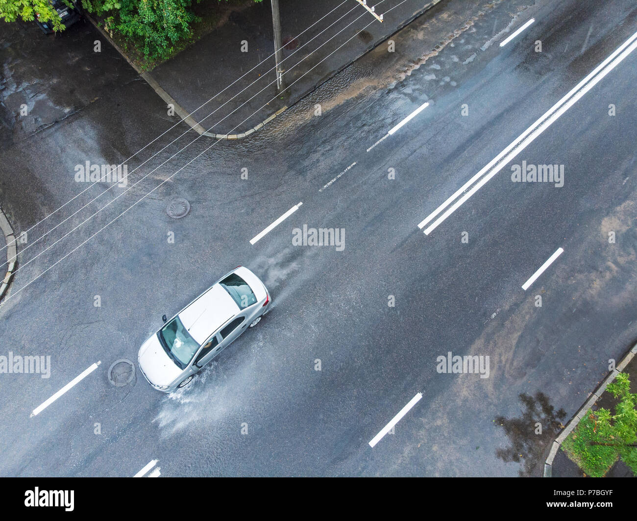 Corse in auto attraverso strade allagate in giorno piovoso. foto aerea Foto Stock