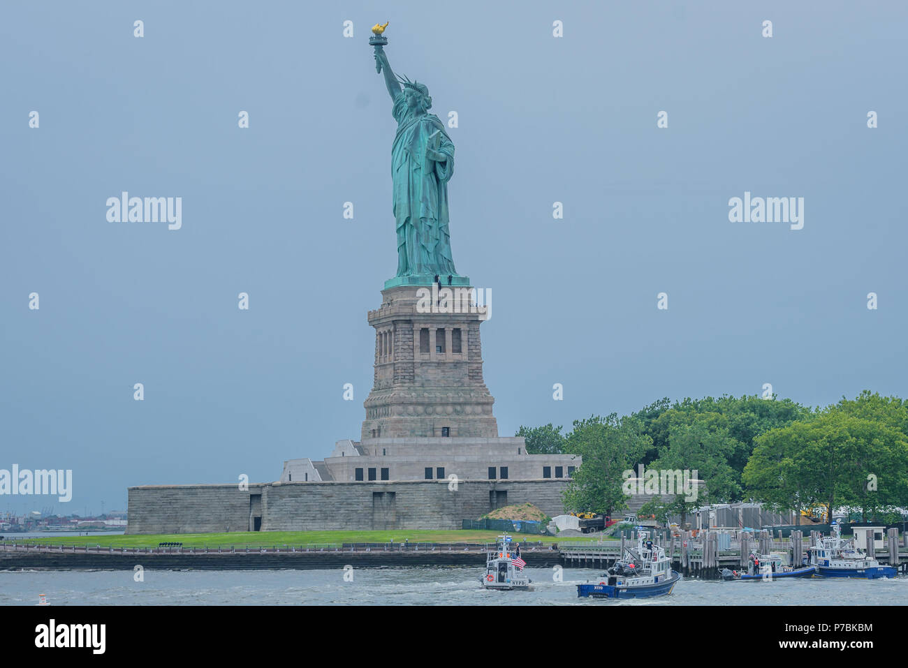 New York, Stati Uniti. 04 Luglio, 2018. Liberty Island è stata evacuata a causa di una persona arrampicata la Statua della Libertà della base sul quarto di luglio poco dopo sette manifestanti che ostentano un 'abolire ghiaccio' banner dalla statua di colonnina per chiedere la soppressione di immigrazione e dogane esecuzione erano stati arrestati. Credito: Erik McGregor/Pacific Press/Alamy Live News Foto Stock