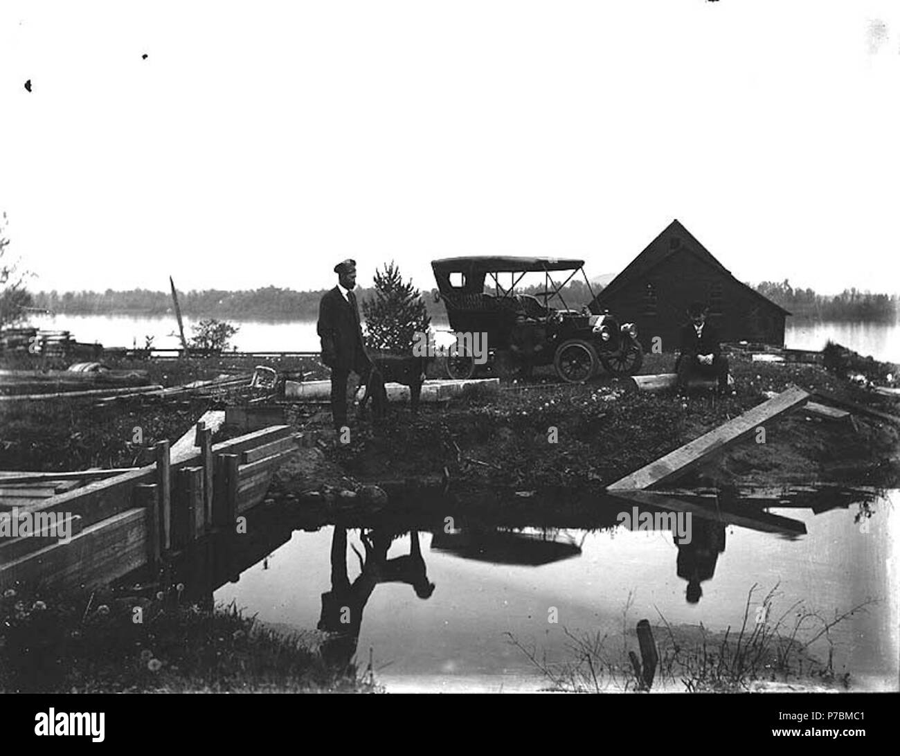 . Inglese: tre uomini presso il sito circondata da acqua e costruzione con tavole di legno . Inglese: 3 uomini, vecchia auto. Visualizzazione di un qualche tipo di costruzione. Soggetti (LCTGM): corpi di acqua--Washington (stato); automobili--Washington (stato); costruzione--Washington (stato) . Data sconosciuta 80 tre uomini presso il sito circondata da acqua e costruzione con doghe in legno (barra 41) Foto Stock