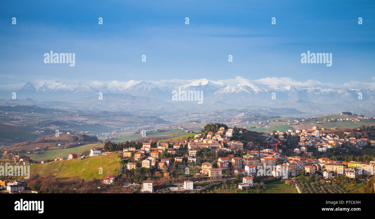 Provincia di Fermo, Italia. Paesaggio panoramico del paesaggio italiano. Villaggio sulla collina sotto il cielo blu Foto Stock