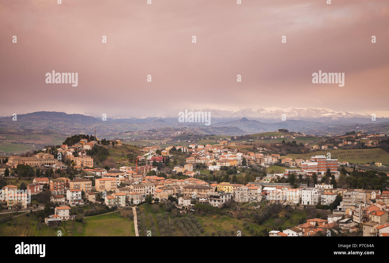 Campagna Italiana, rurali paesaggio panoramico. Provincia di Fermo, Italia. I villaggi e i campi sulle colline sotto il cielo colorato Foto Stock