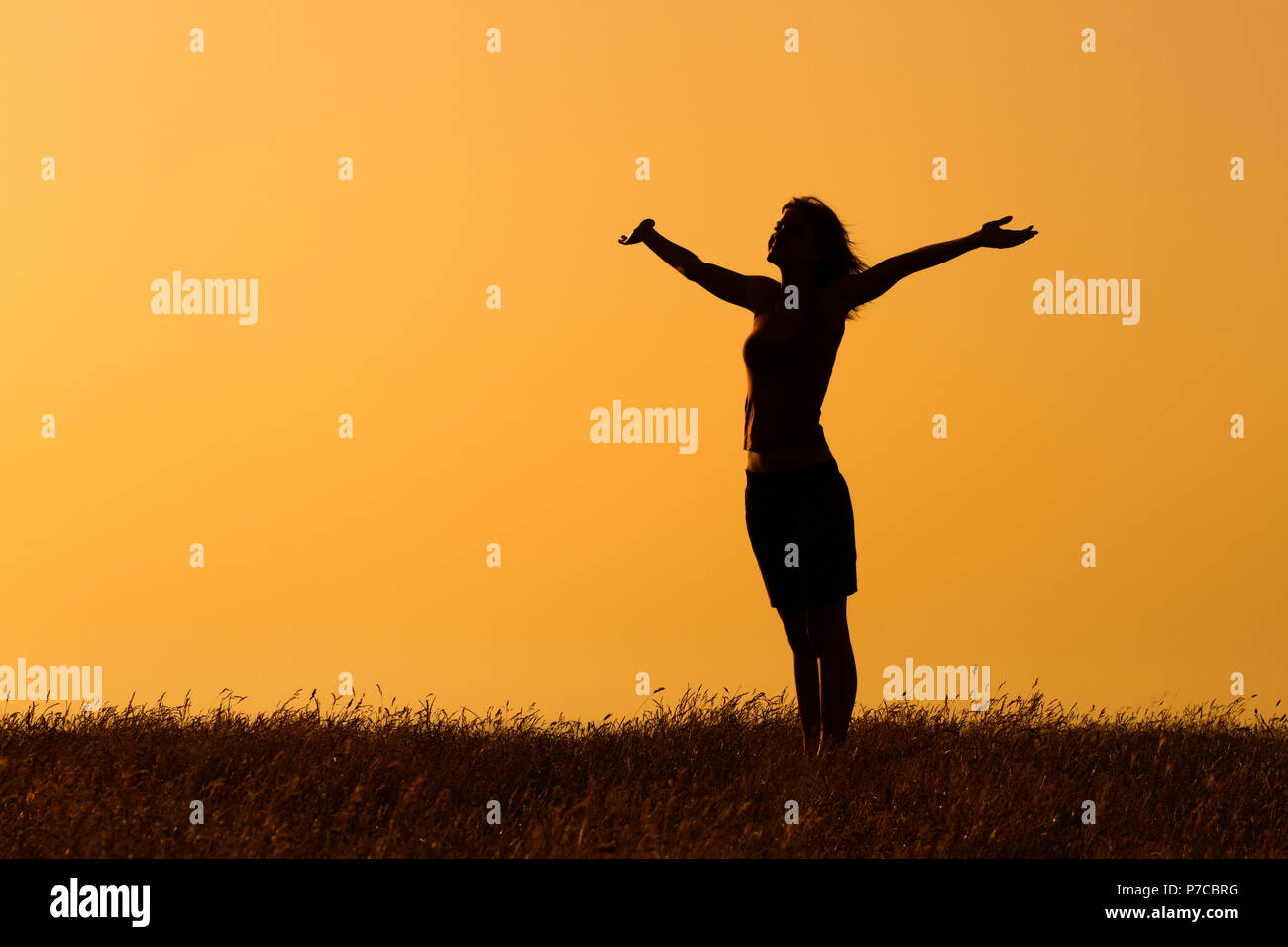 Silhouette di donna con le braccia aperte. Foto Stock