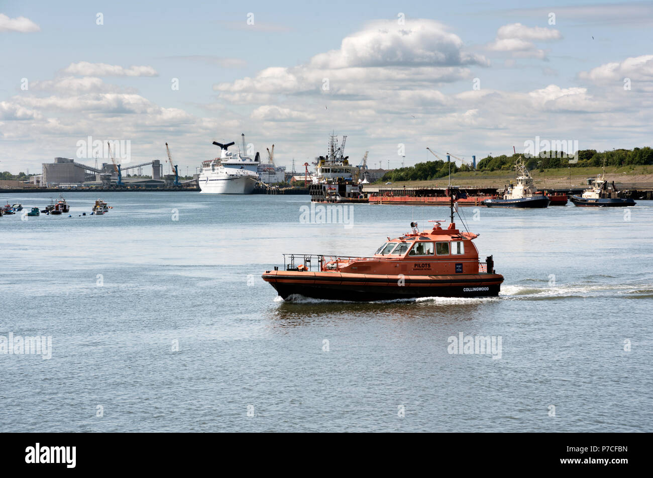 Una barca pilota attraversa il fiume Tyne, con una nave ormeggiata al porto delle navi traghetto in background, North Shields, Tyneside, Regno Unito Foto Stock