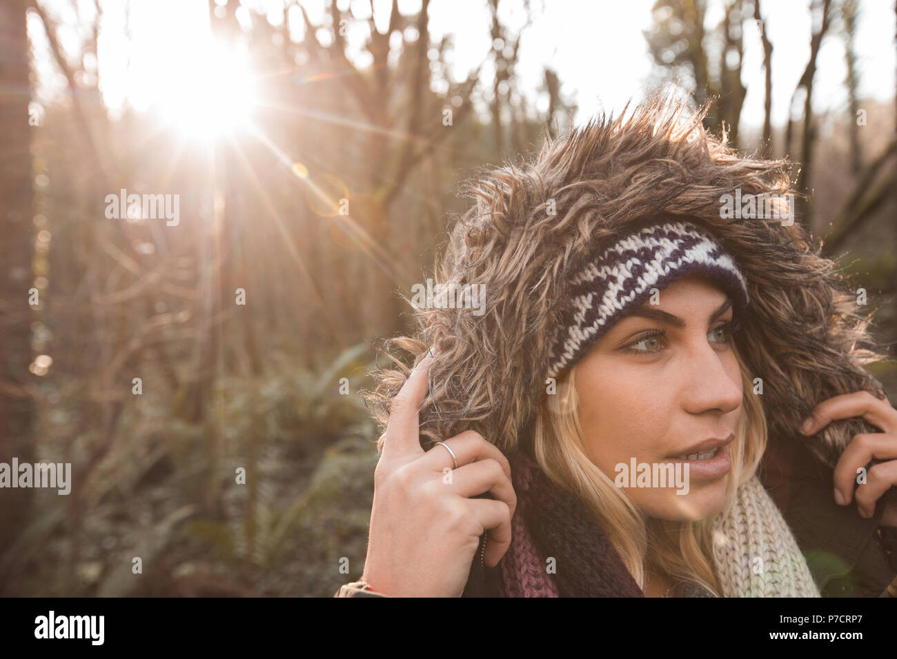 Donna in felpa con cappuccio permanente al bosco Foto Stock