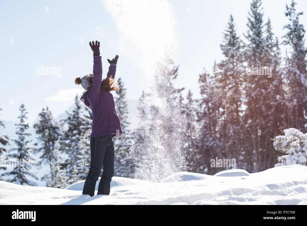 Donna che gioca con la neve nel paesaggio innevato Foto Stock