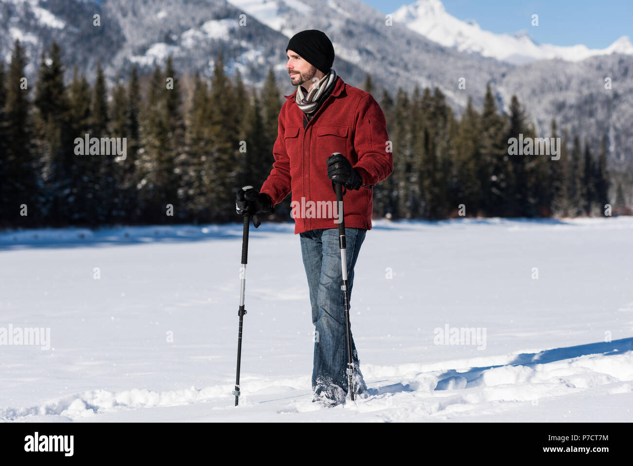 Uomo che cammina con bastoncino da sci nel paesaggio innevato Foto Stock