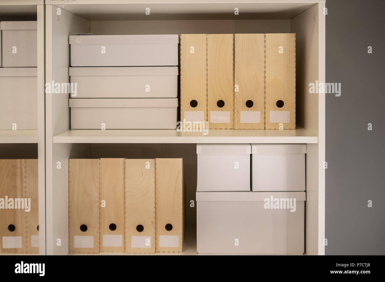 Archivio di documenti e cartelle di caselle bianche su scaffalature di legno Foto Stock