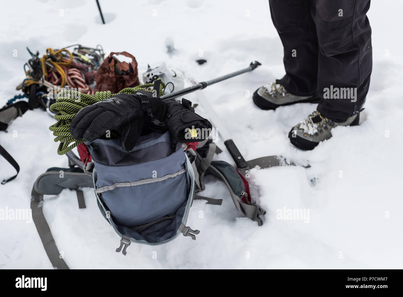 Escursionista in piedi con zaino e attrezzature su regione nevosa Foto Stock