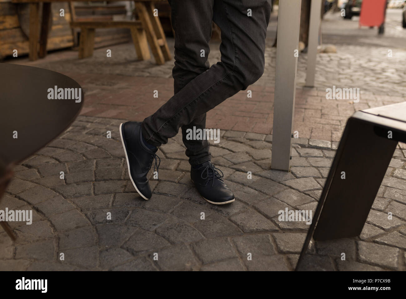 Imprenditore in piedi nel cafe' sul marciapiede Foto Stock