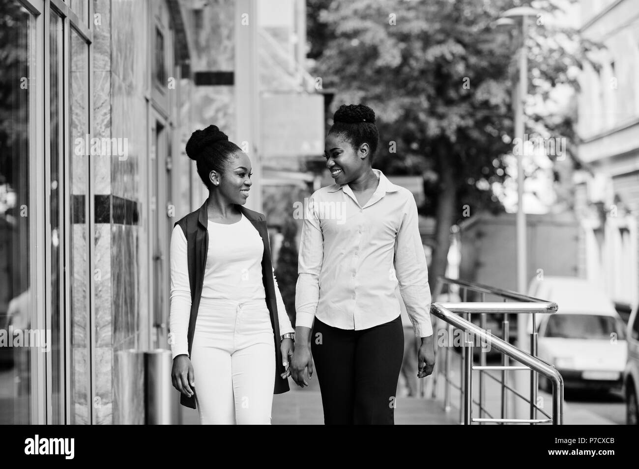 Due eleganti african american ragazze amici poste all'aperto delle vie della città. Foto Stock