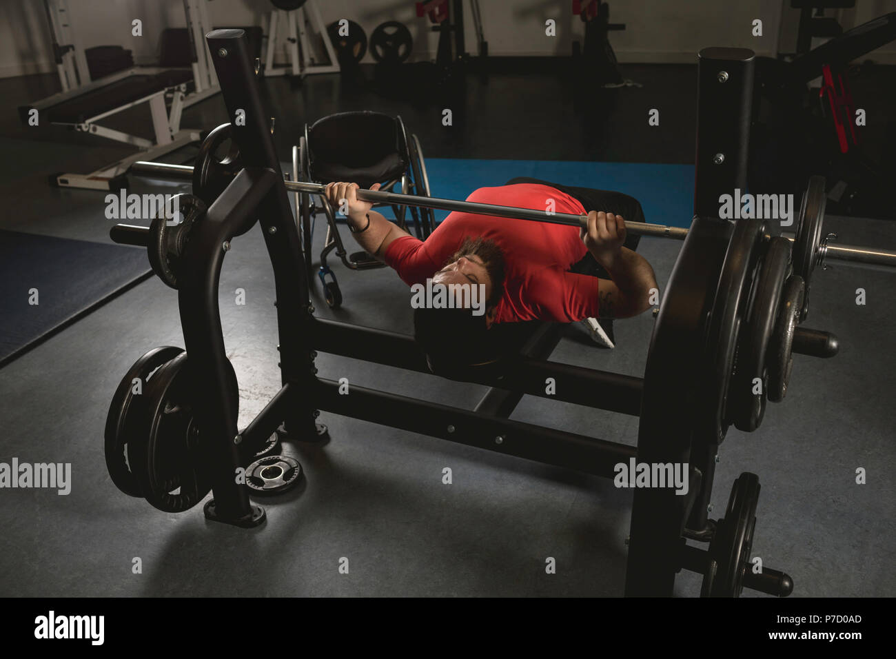 Uomo disabile facendo petto allenamento sulla pressa da banco con barbell Foto Stock
