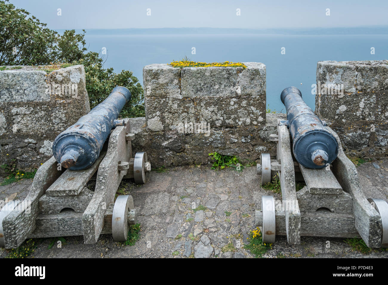 Due grandi cannoni in ottone sulla parte esterna di mura difensive di St Michaels Mount fortezza, Marazion vicino a Penzance, Cornwall, Regno Unito Foto Stock