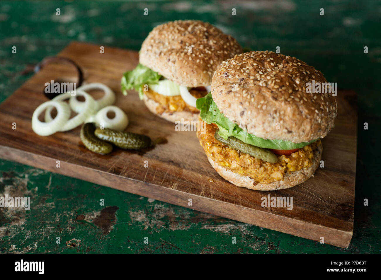 Hamburger vegano con tortino di mais, sottaceti e cipolle, cibo still-life, studio shot Foto Stock