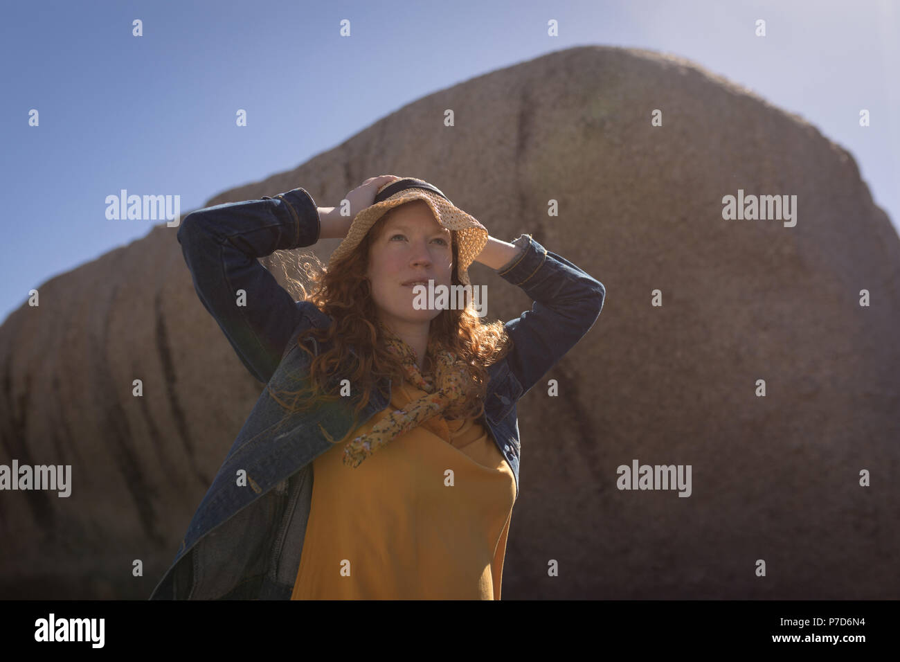 Donna in piedi con le mani sulla testa a beach Foto Stock