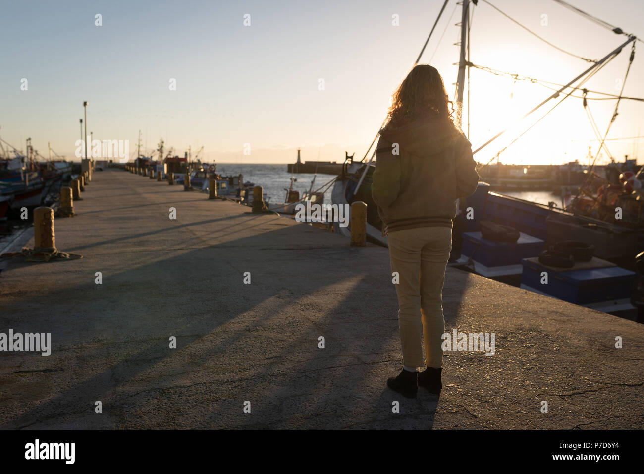 Donna in piedi sul molo vicino alla barca Foto Stock