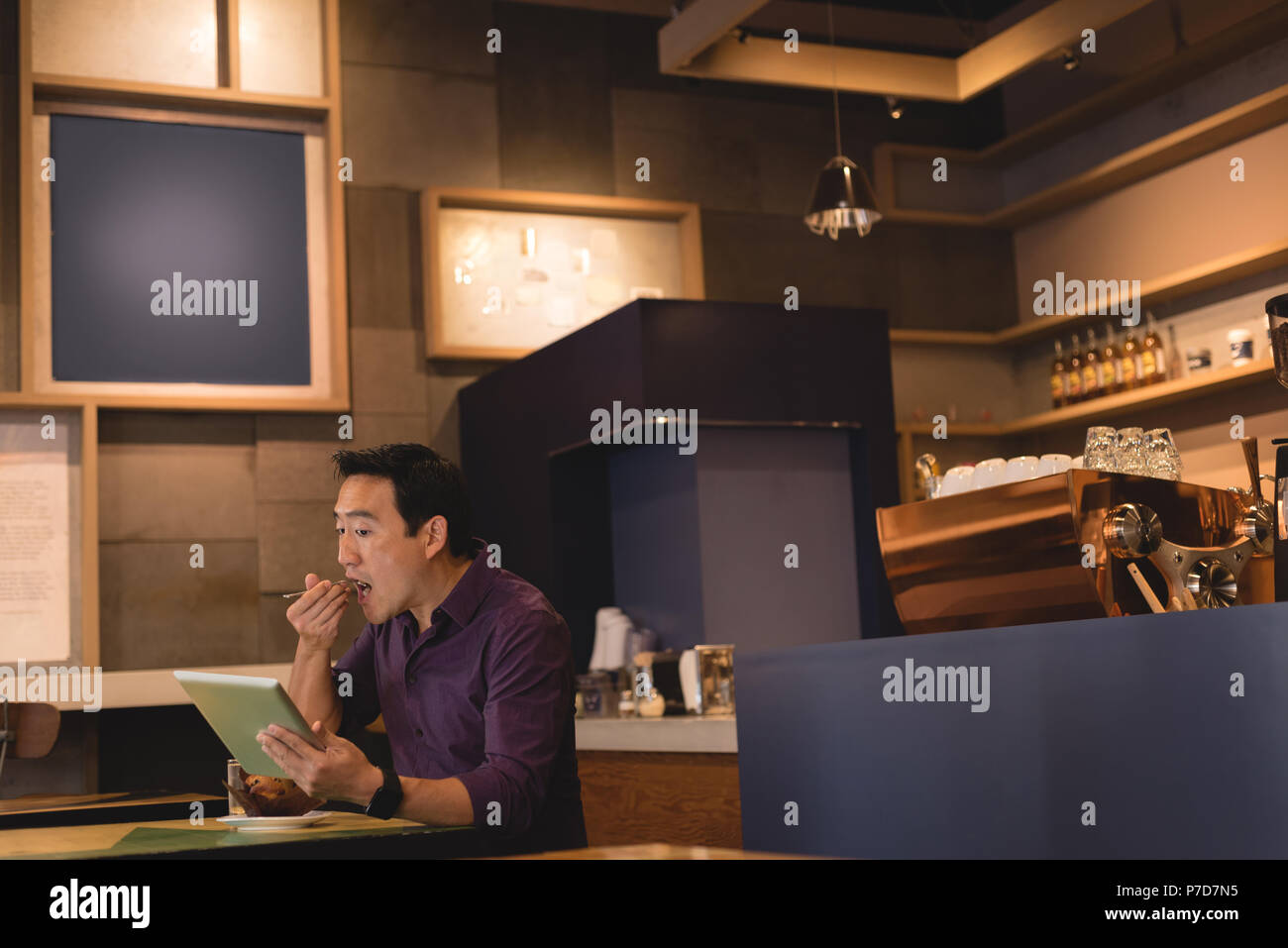Uomo con tavoletta digitale nel coffee shop Foto Stock