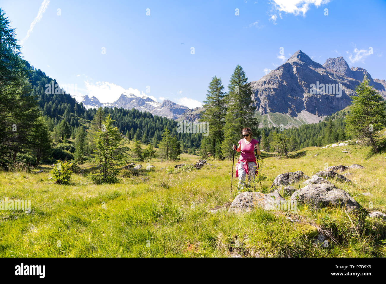 Donna nella sua 30's passeggiate in montagna in estate Foto Stock