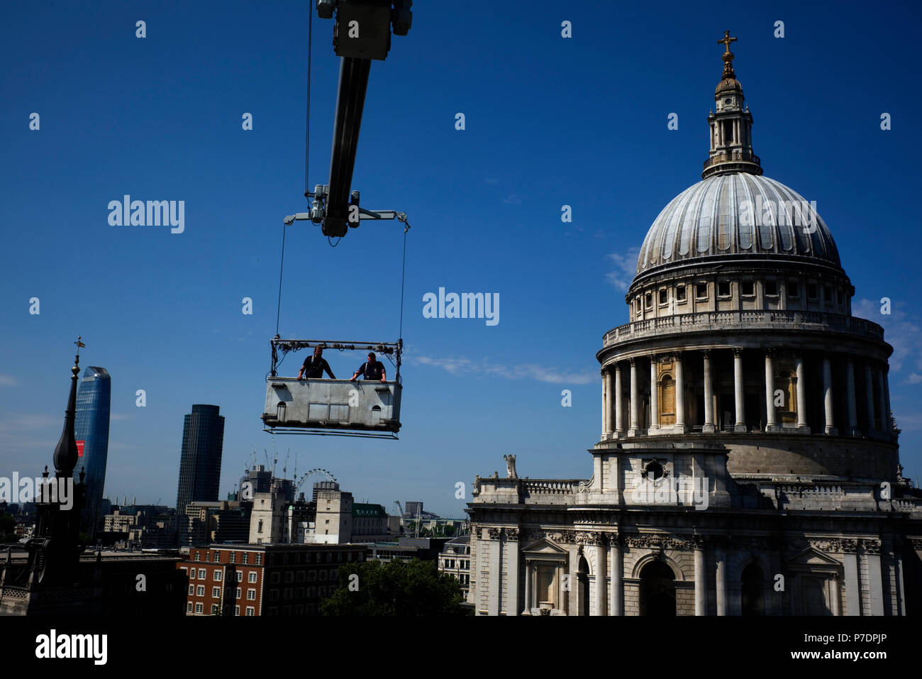 Detergenti per finestre sono sospesi in una culla al di sopra di un blocco di uffici accanto alla Cattedrale di St Paul, nel centro di Londra, Gran Bretagna Luglio 3, 2018. Foto Stock