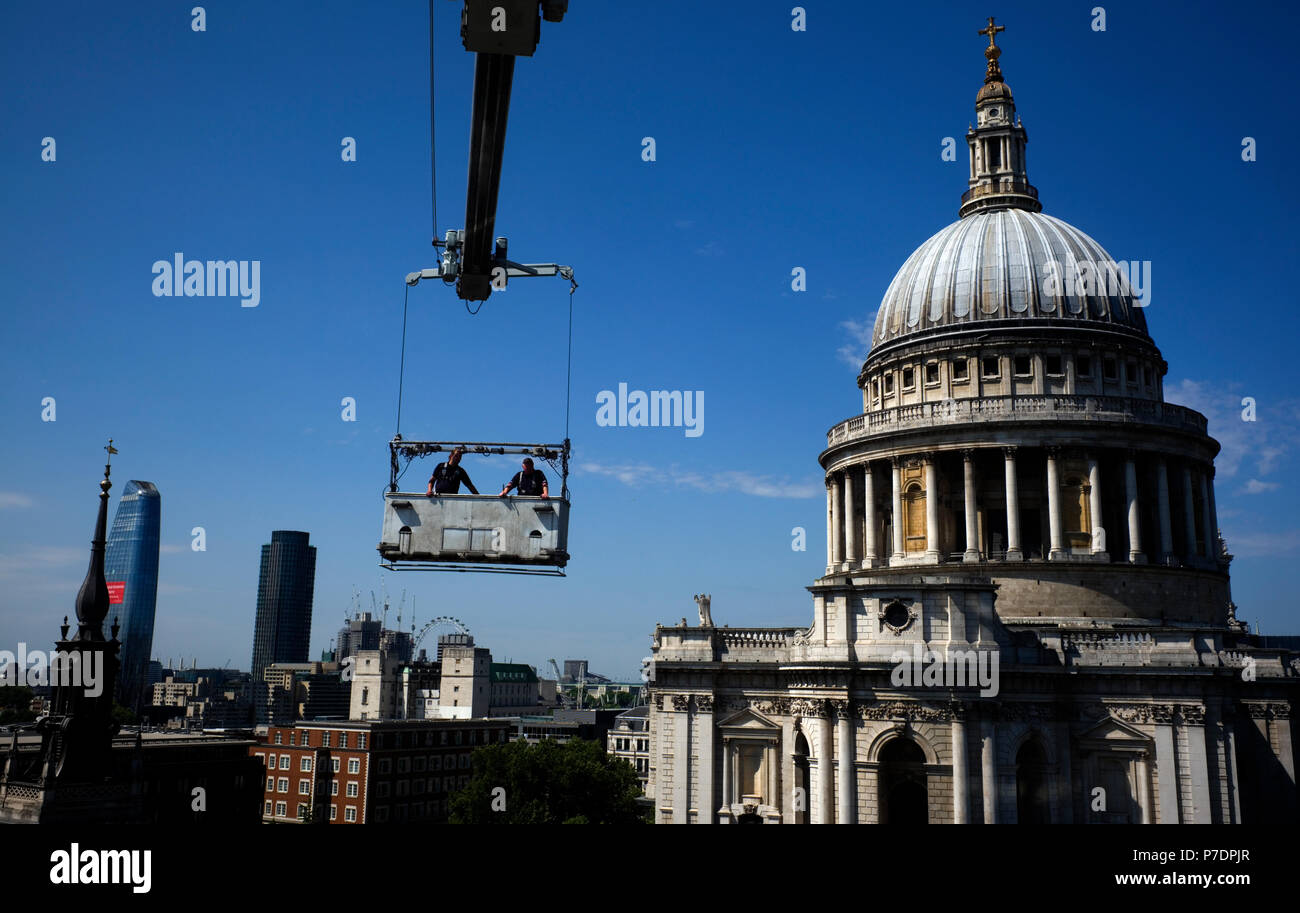 Detergenti per finestre sono sospesi in una culla al di sopra di un blocco di uffici accanto alla Cattedrale di St Paul, nel centro di Londra, Gran Bretagna Luglio 3, 2018. Foto Stock