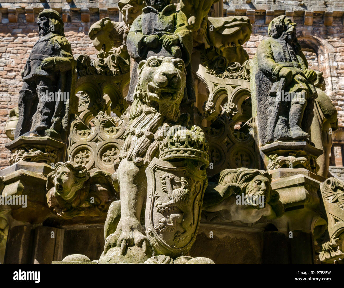 Dettaglio di indossato scolpiti leone rampante e figure, ornata fontana di pietra nel cortile centrale, Linlithgow Palace, West Lothian, Scozia, Regno Unito Foto Stock