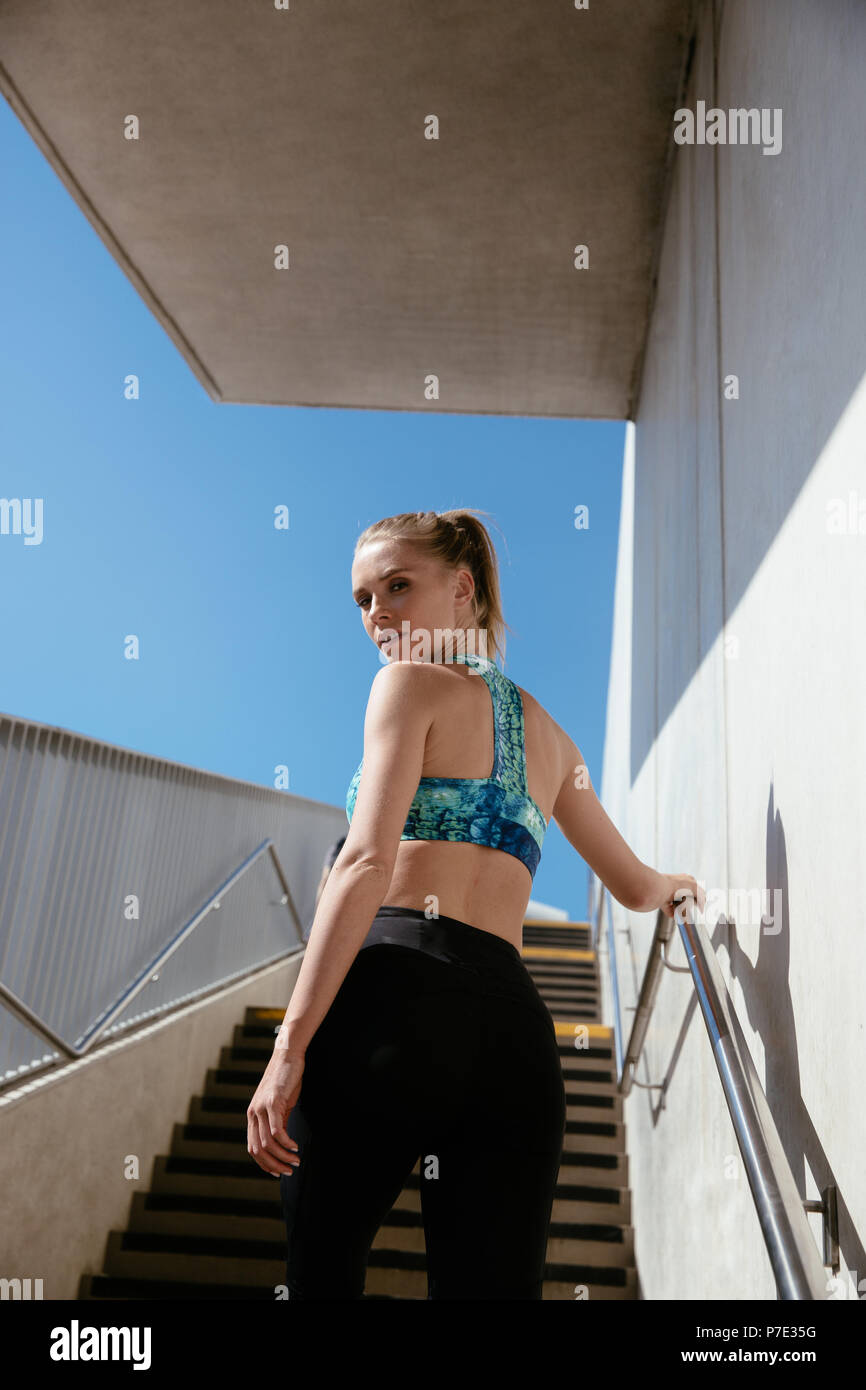 Giovane donna salendo le scale Foto Stock