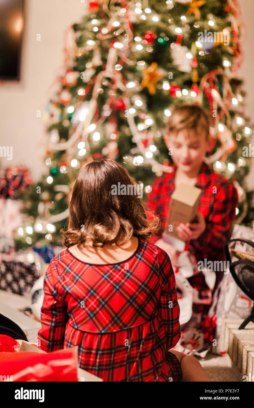 I fratelli di aprire i regali di Natale con albero di Natale Foto Stock