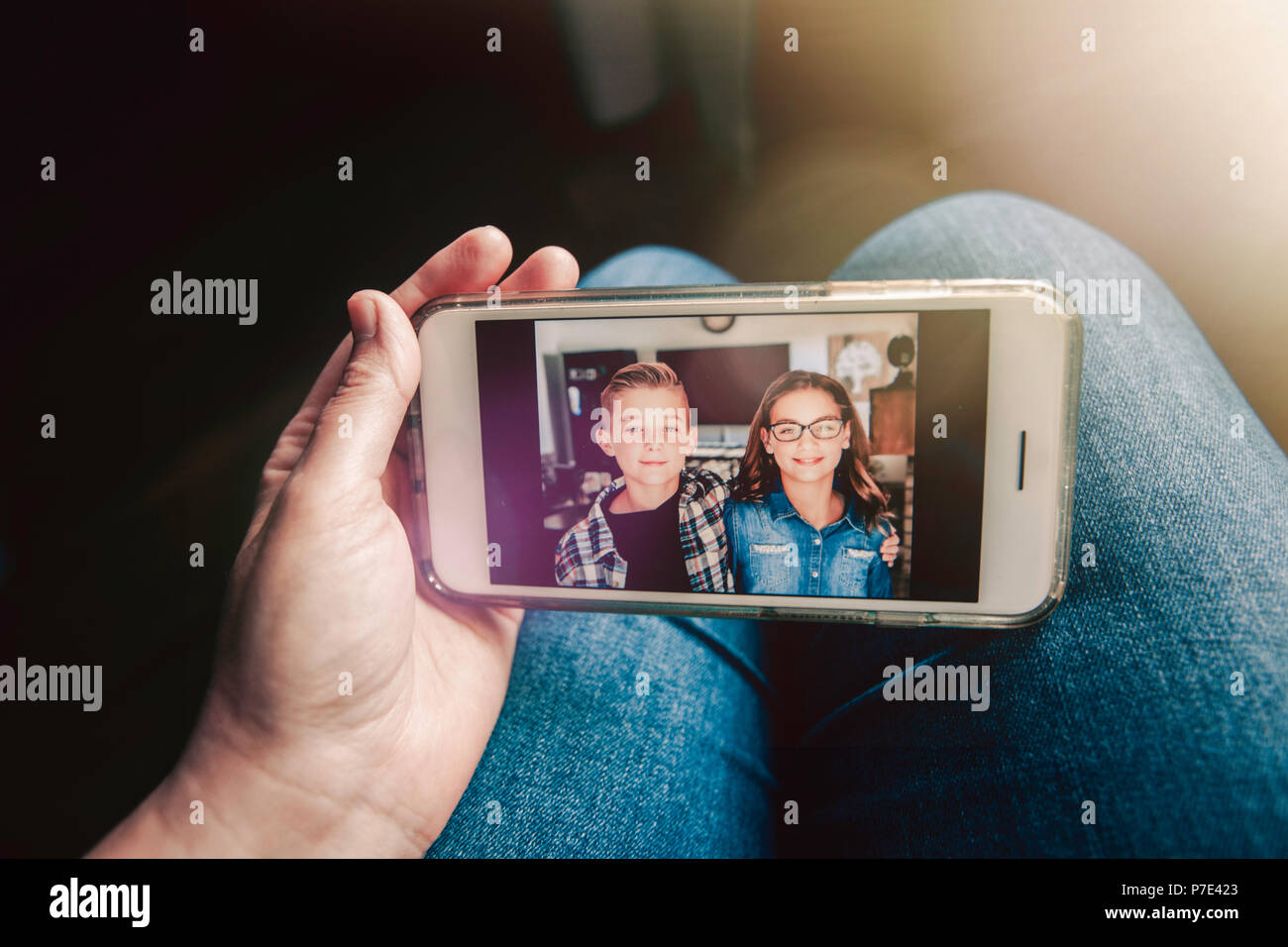 Madre tenendo lo smartphone con il messaggio con immagini di twin ragazzo e una ragazza, prospettiva personale Foto Stock