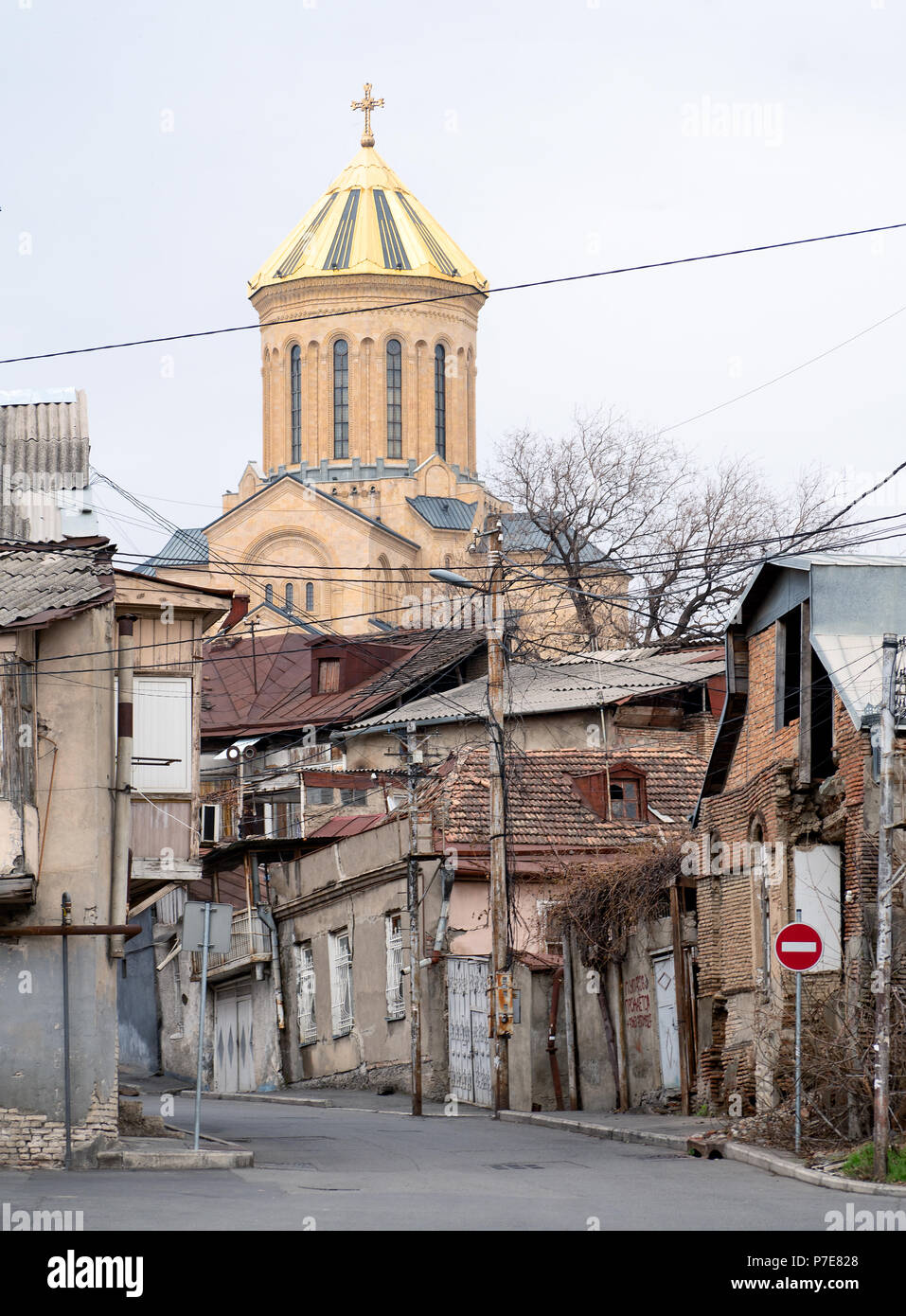 Tbilisi street scene : Santa Trinità cattedrale dietro la vecchia casa in rovina Foto Stock