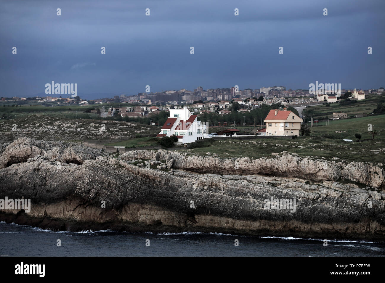 Case vicino alla scogliera rocciosa che domina l'oceano Atlantico vicino Gijon, Asturias, Spagna Foto Stock