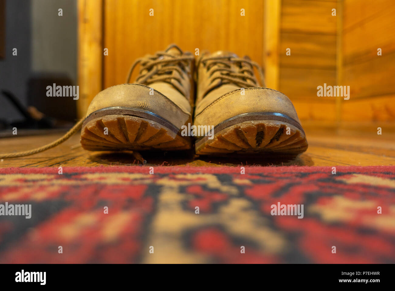 Close up di scarponi posto vicino alla porta in un caldo cottage di legno. Concetto di riposo, rilassante e confortevole. Foto Stock