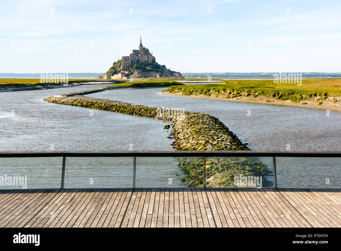 Vista del Mont Saint Michel isola di marea in Normandia, Francia, ad alta marea con il cavalcavia sopra la diga sul fiume Couesnon in primo piano. Foto Stock