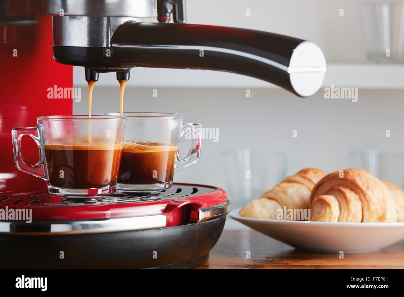Caffè caldo in esecuzione in due tazze. Facendo espresso in vetro trasparente tazza di caffè. Foto Stock