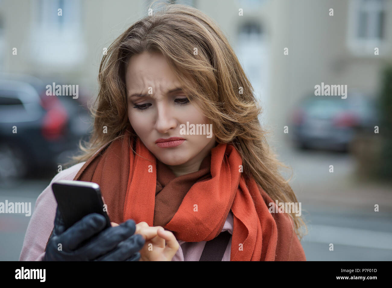 Closeup ritratto divertente triste donna cercando di pensare vedendo bad news sms commento trolling messaggio foto telefono in mani disgustoso emozione sulla faccia iso Foto Stock