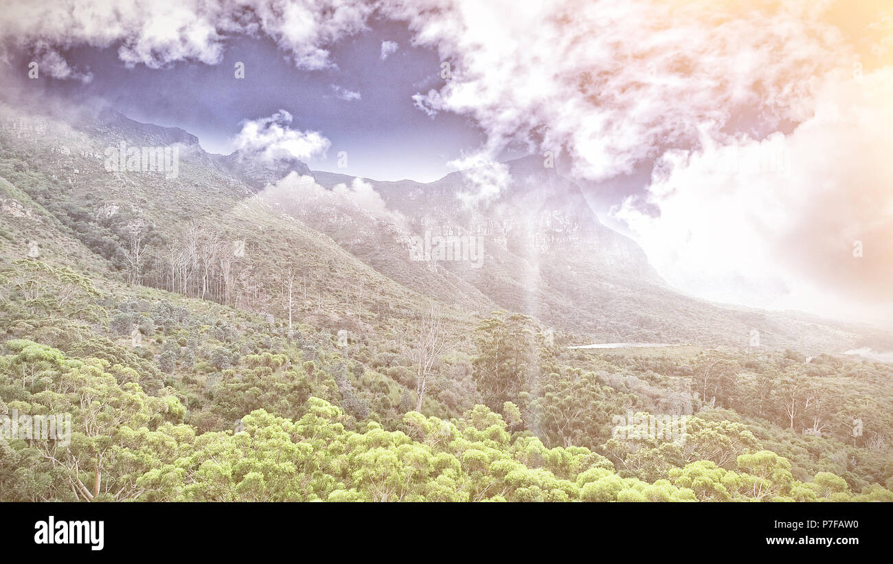 Montagne uder nuvole verdi alberi della foresta Foto Stock